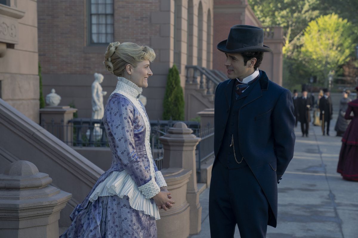 Louisa Jacobson och Harry Richardson står och ler mot varandra på gatan i en stillbild från The Gilded Age säsong 2