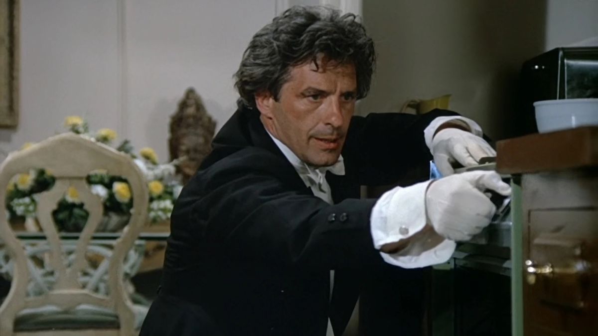 John Cassavetes, iklädd svart kostym och vita handskar, försöker dölja ett mord han begick i Columbo-avsnittet Étude in Black 