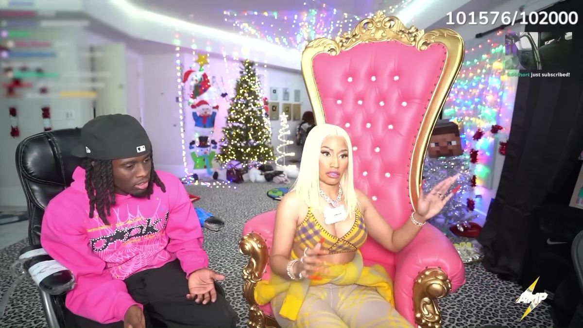 En stillbild från en stream som visar Kai Cenat och Nicki Minaj.  Hon sitter på en tronliknande rosa stol och Kai sitter i en kontorsstol bredvid henne.  Minaj tittar på chatten och Kai tittar ner medan han pratar med henne.  De är i en källare som har en julgran i bakgrunden.