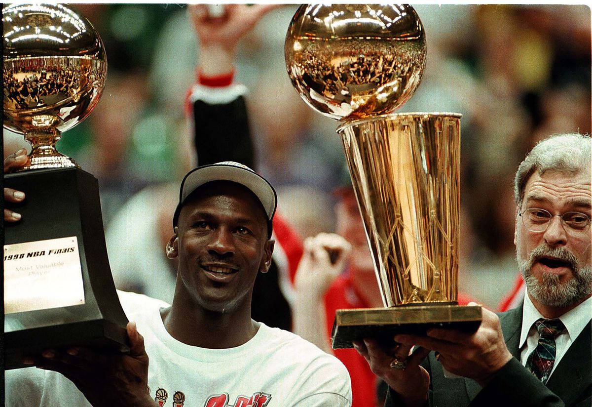 Michael Jordan innehar sin MVP-finalpokal medan Phil Jackson innehar NBA-mästerskapstrofén 1998.