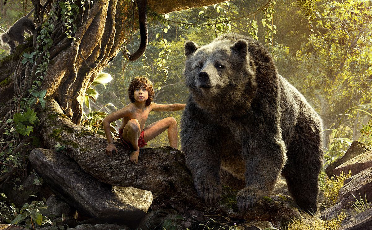 Live-action Mowgli and CG Baloo the bear side-by-side in the jungle in a scene from the 2016 version of The Jungle Book