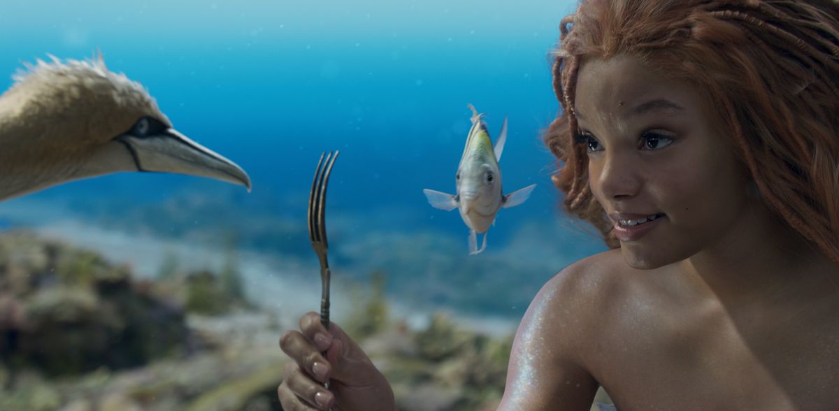 Ariel (Halle Bailey) holds up a fork to show to her bird friend Scuttle and her fish friend Flounder in the live-action 2023 Little Mermaid remake