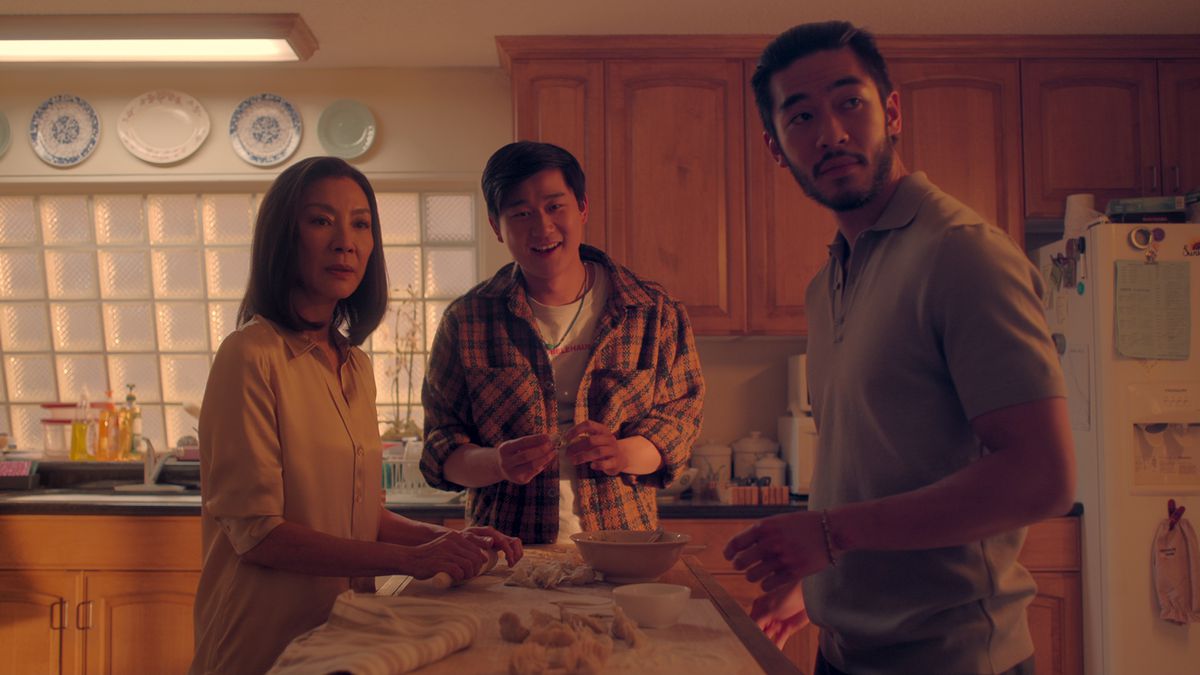 Mama Sun står vid köksbänken med sina stora vuxna söner Bruce och Charles i The Brothers Sun.