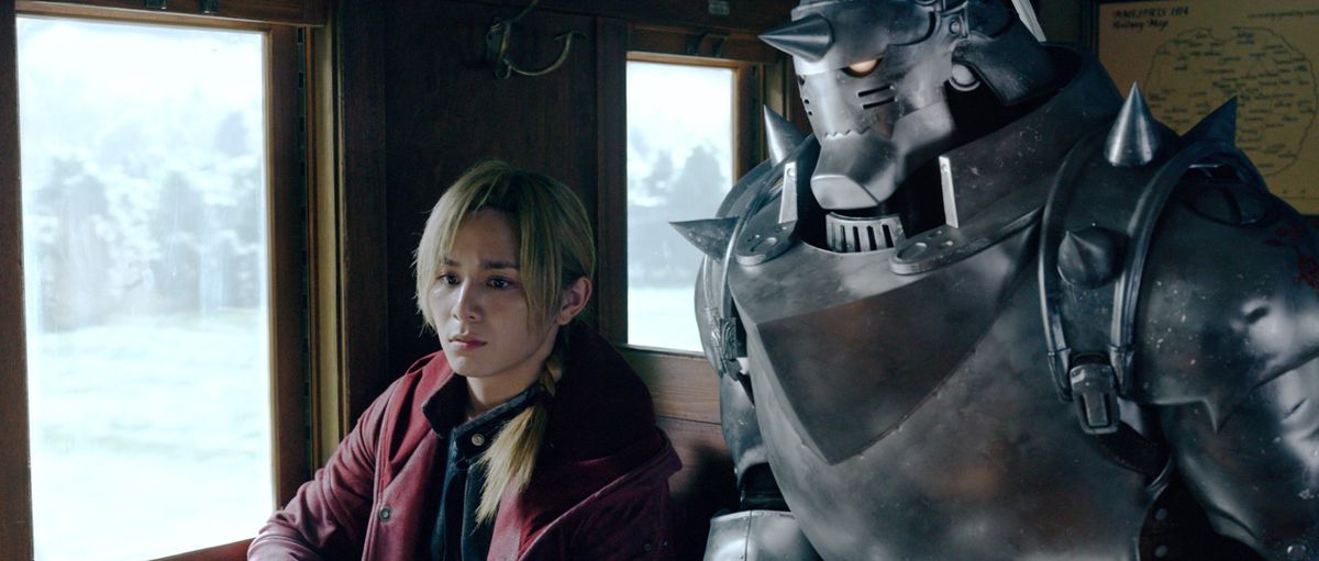 Edward and Alphonse Elric sitting in a train car in Fullmetal Alchemist.