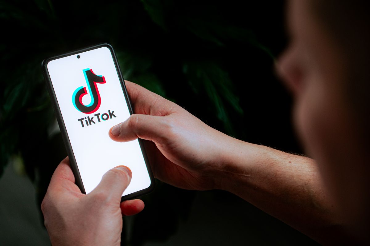 En fotoillustration som visar en TikTok-logotyp som visas på en mobiltelefon.