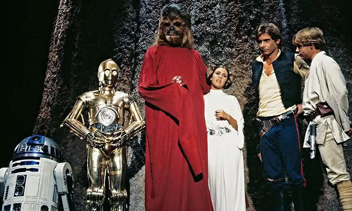 En publicitetsbild från Star Wars Holiday Special 1978 visar R2-D2, C-3PO, Chewbacca (i en lång röd mantel), Carrie Fisher som prinsessan Leia, Harrison Ford som Han Solo och Mark Hamill som Luke Skywalker, alla stående tillsammans framför en hög, kornig sten