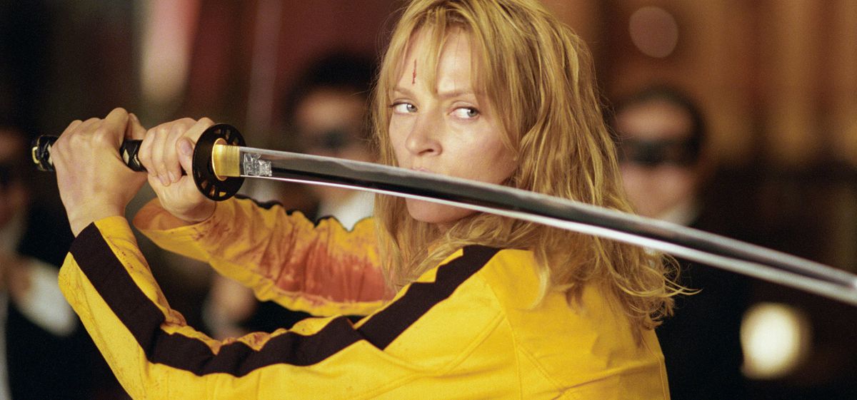 Klädd i en gul jumpsuit poserar Beatrix med sitt svärd i Kill Bill: Volym 1
