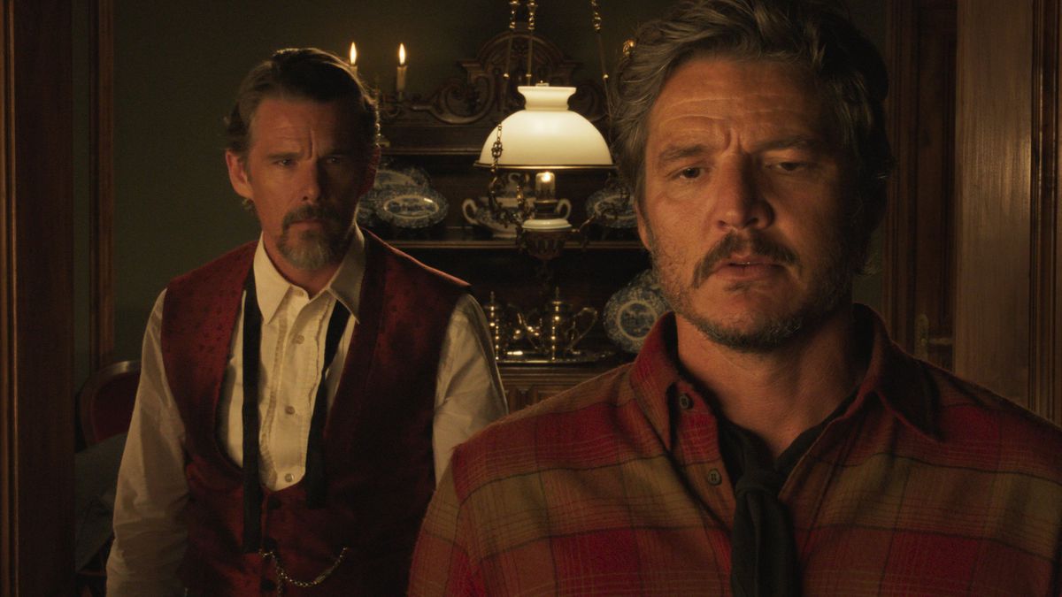 Two men (Ethan Hawke, Pedro Pascal) standing in a dimly lit dining room in Strange Way of LIfe.