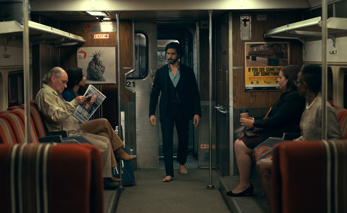 Ezekiel Sims (Tahar Rahim) går genom en tunnelbanevagn i New York City, iklädd kostym, blå skjorta och inga skor (eh, på SUBWAY?!) i Madame Web