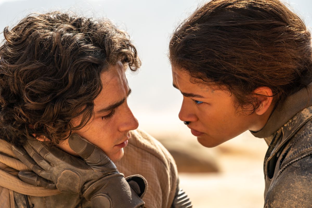 Timothée Chalamet och Zendaya står ansikte mot ansikte när Paul Atreides och Chani bär stillbildsdräkter i öknen i Dune: Part Two 