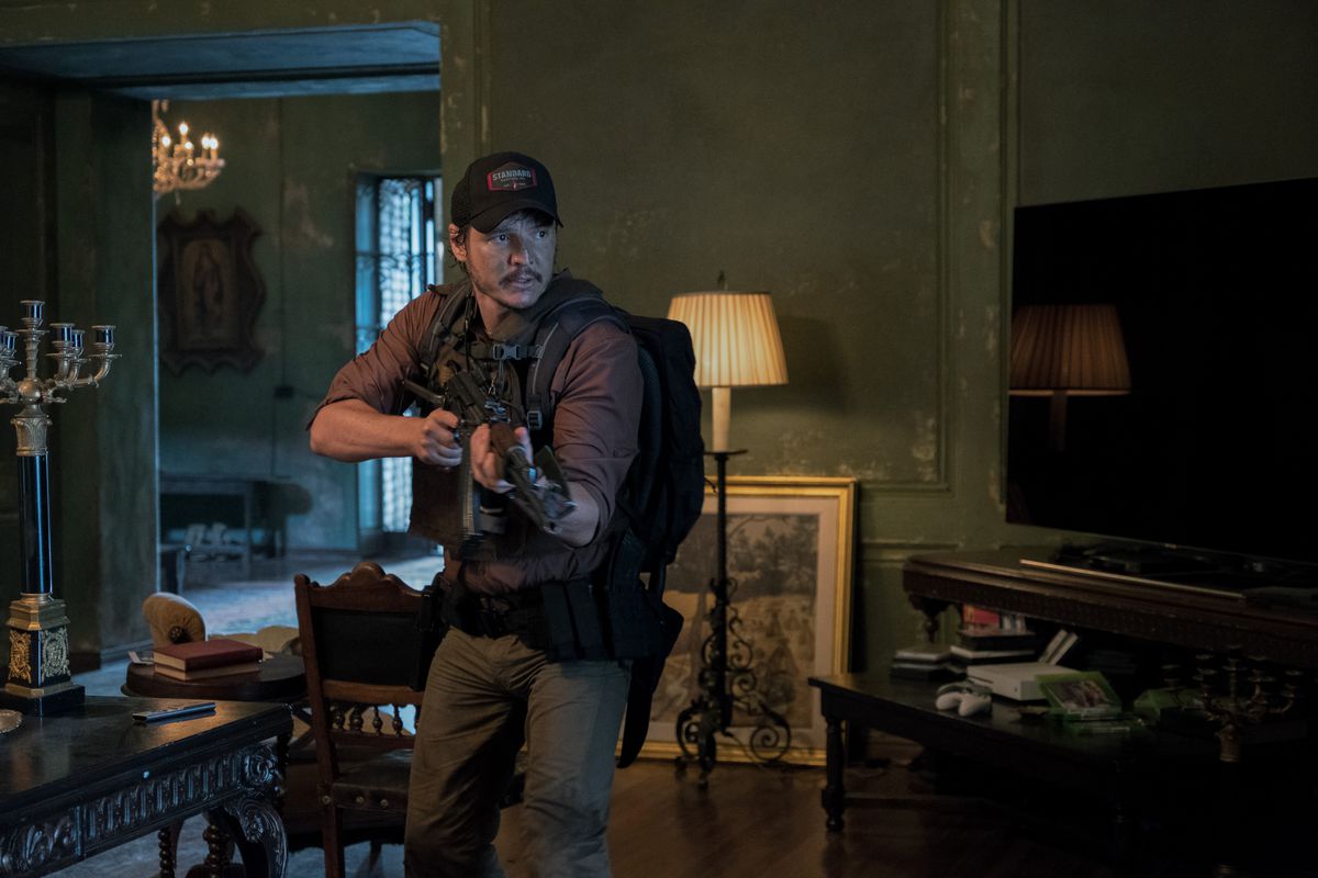 Pedro Pascal håller en pistol och bär en ryggsäck i ett utsmyckat hus i Triple Frontier.