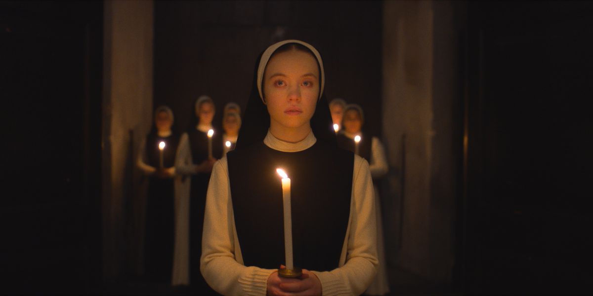 Sydney Sweeney i Immaculate håller ett ljus med nunnor bakom sig 