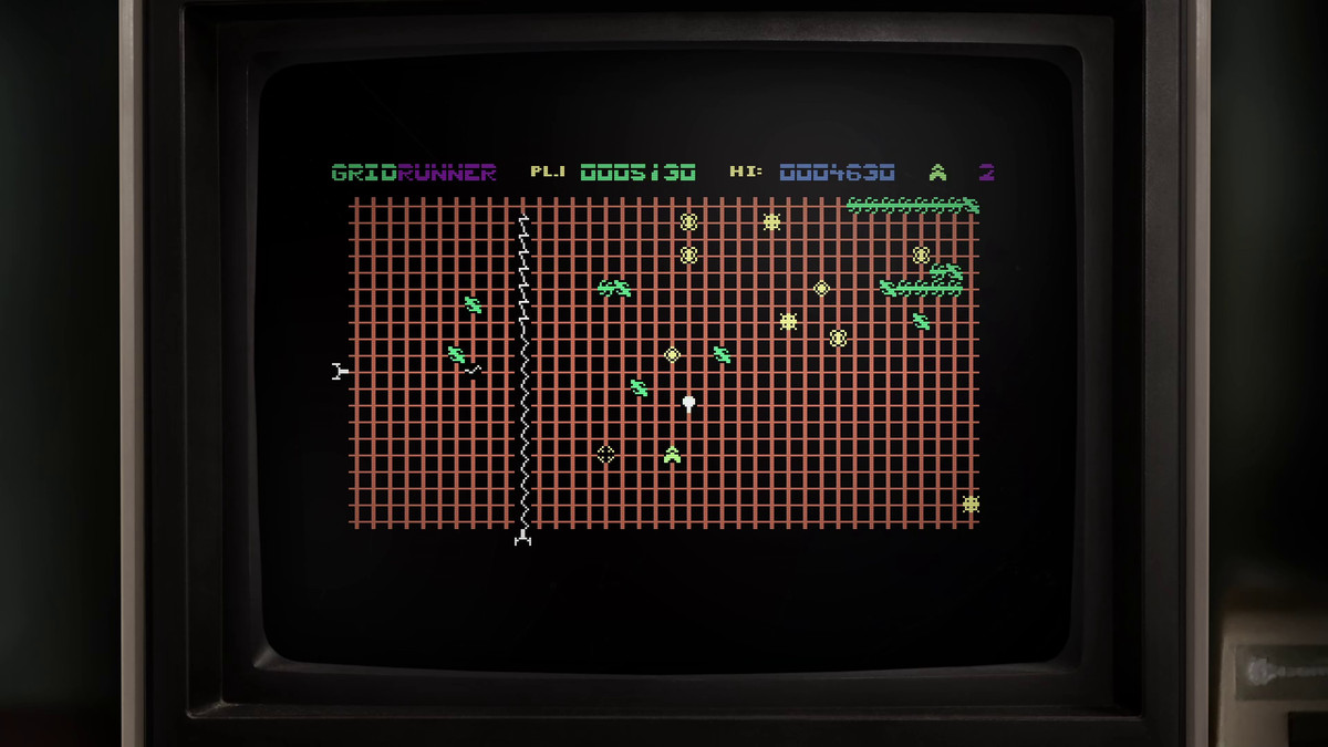 En skärmdump av Gridrunner, inramad av en gammal TV-monitor, som visar dess enkla 8-bitars grafik