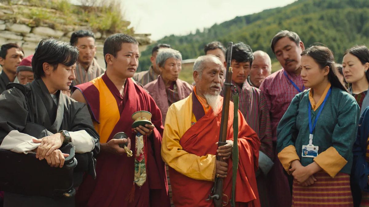 En grupp bybor och munkar som beundrar ett antikt gevär.