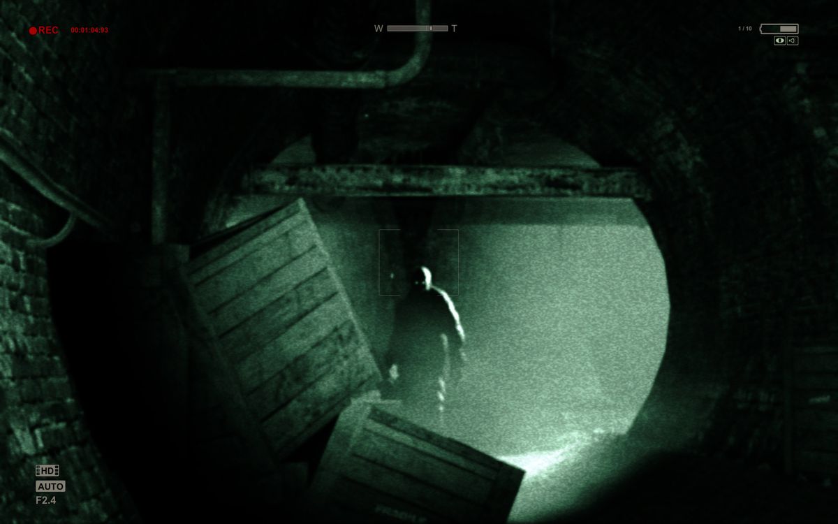 An ominous figure standing at the end of a tunnel, viewed from the point of view of a handheld camera with night vision.