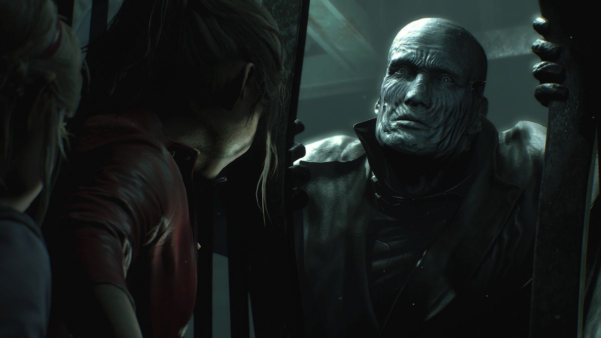 The Tyrant monster pulls apart a metal fence separating him from Claire Redfield and Sherry Birkin in a screenshot from the Resident Evil 2 remake.