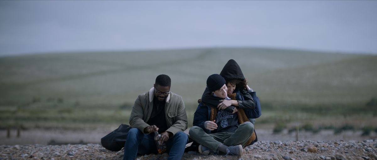 Jovan Adepo som Saul Durand, Alex Sharp som Will Downing, Eiza González som Auggie Salazar på en strand i en stillbild från 3 Body Problem