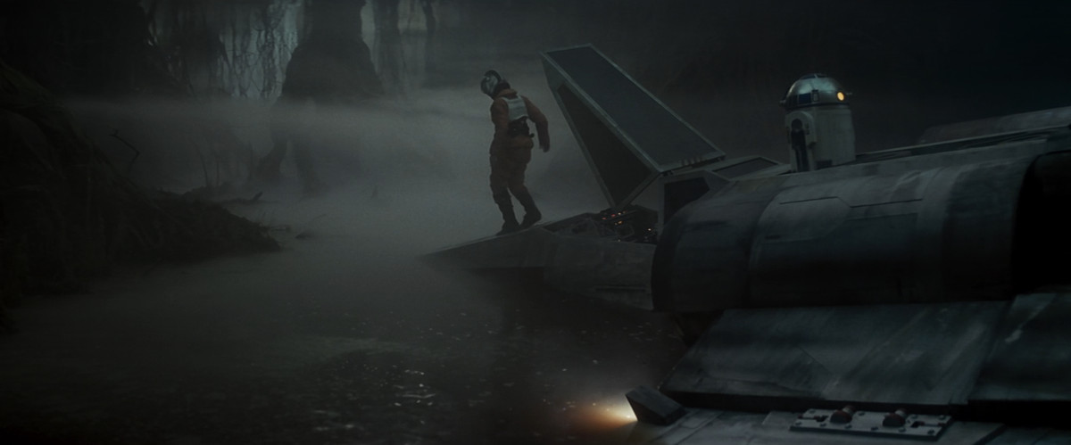 Luke Skywalker står på sin halvsjunkna x-wing fighter i Dagobah träsket.