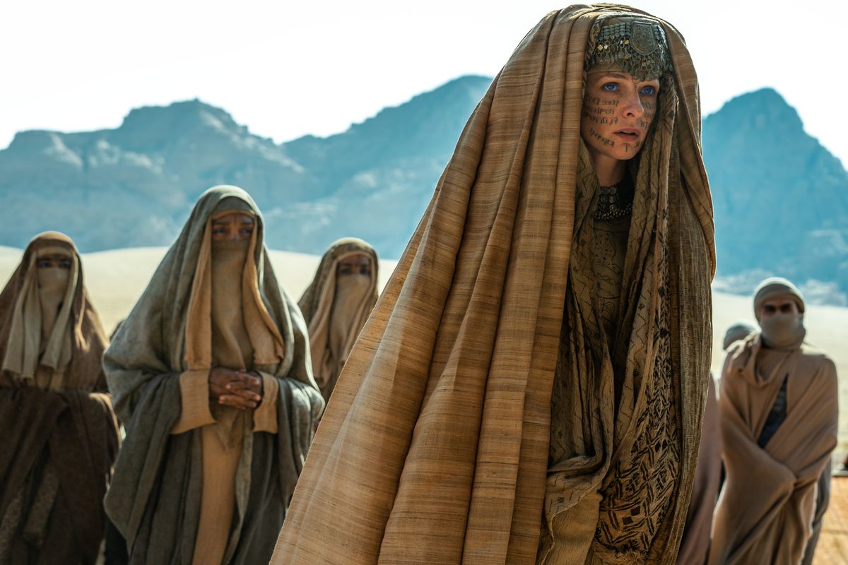 Lady Jessica (Rebecca Ferguson), höljd och med symboler skrivna över ansiktet med bläck, står i öknen, omgiven av liknande klädda figurer i Denis Villeneuves Dune: Part Two