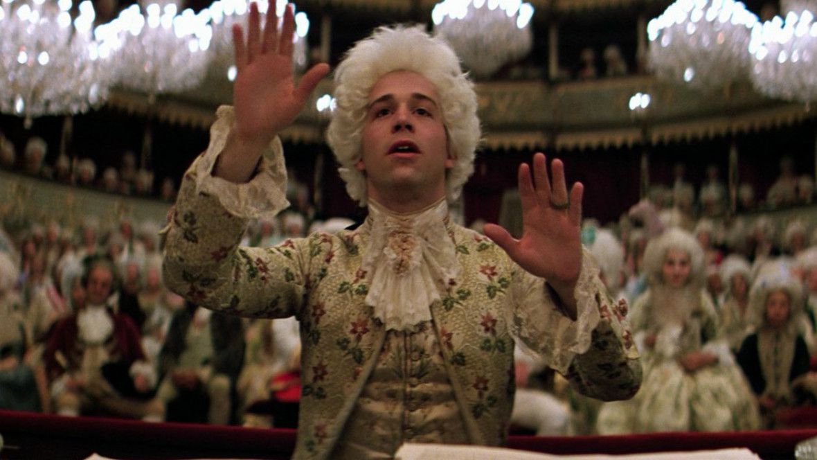 Wolfgang Amadeus Mozart med utsträckta händer, dirigerar en symfoni i Amadeus
