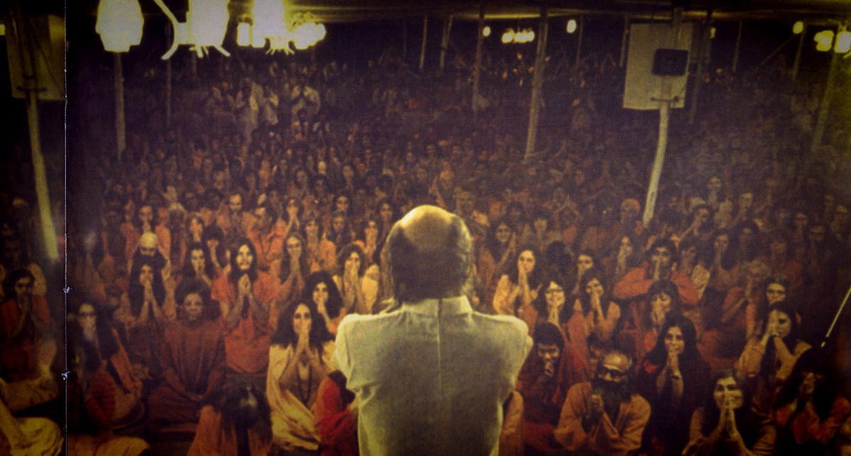 En lite kornig, äldre bild av ett möte ledd av Guru Bhagwan Shree Rajneesh från Wild Wild Country