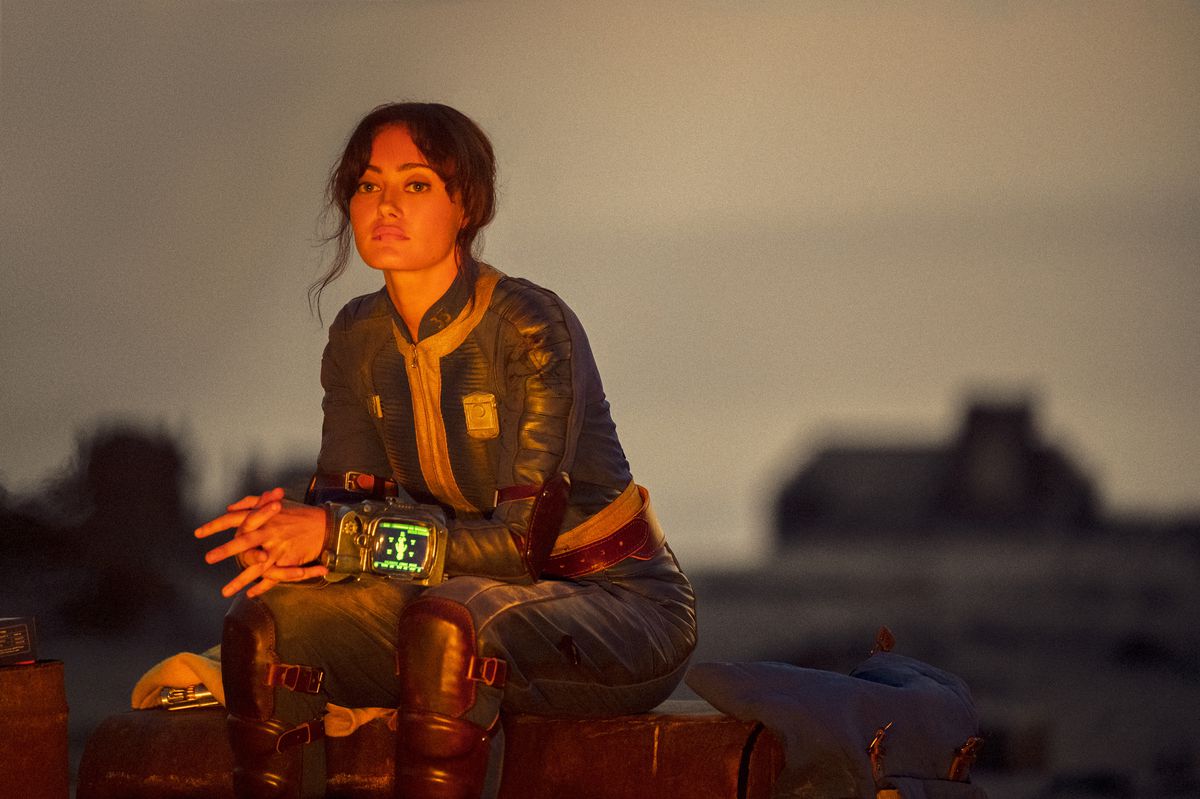 Lucy (Ella Purnell) sitter vid en eld och ser högtidlig ut i en stillbild från Fallout