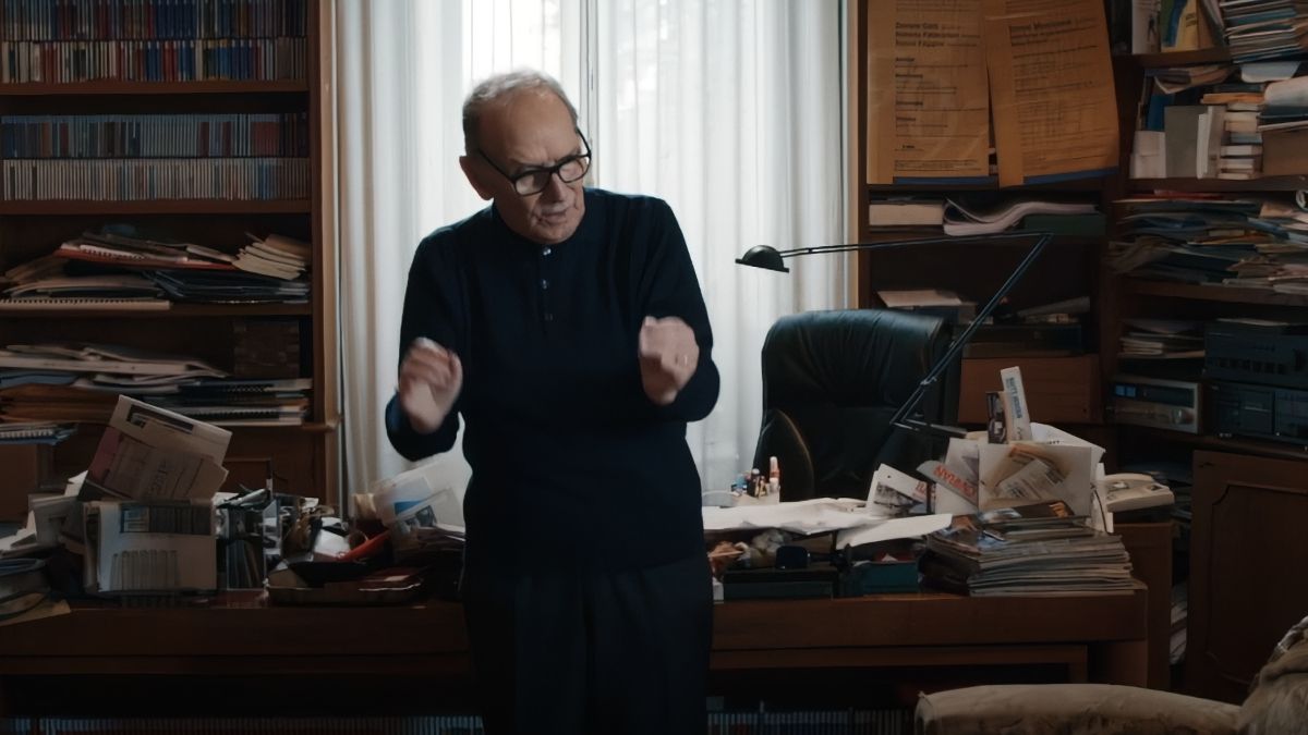 Ennio Morricone standing in his office surrounded by notes.