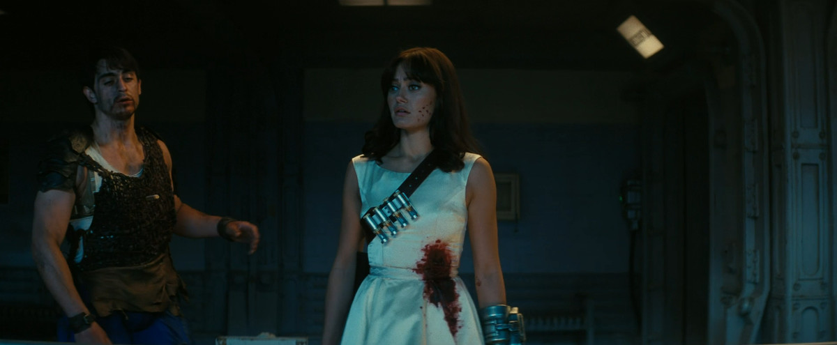 Lucy (Ella Purnell) i en blodig bröllopsklänning, med lugnande pilar över axeln, i Fallout