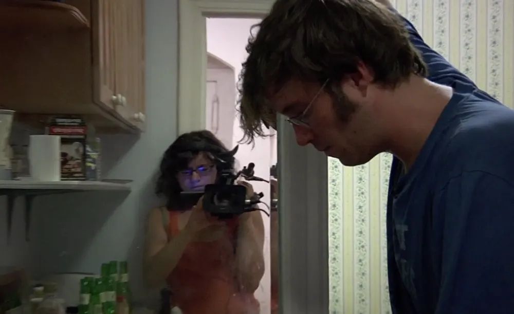Joanna Arnow holds a camera up to her partner in a kitchen in I Hate Myself :)
