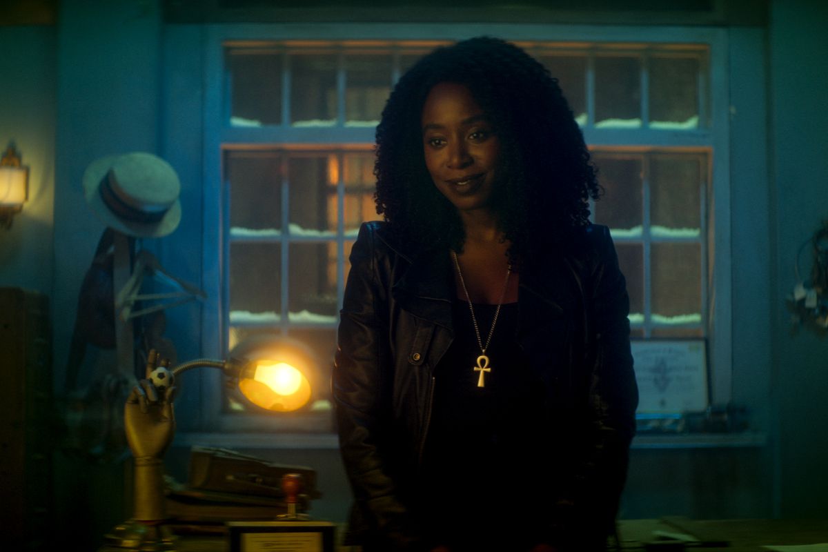 Kirby Howell-Baptiste som Death i Dead Boy Detectives.  Hon är klädd i helsvart, med ett ankh-halsband i guld, stående i ett blåfärgat rum.