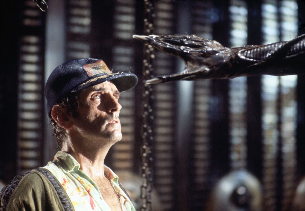 Skådespelaren Harry Dean Stanton på uppsättningen av Alien från 1979, tittar upp med skräck när Xenomorfens hand sträcker sig efter hans huvud