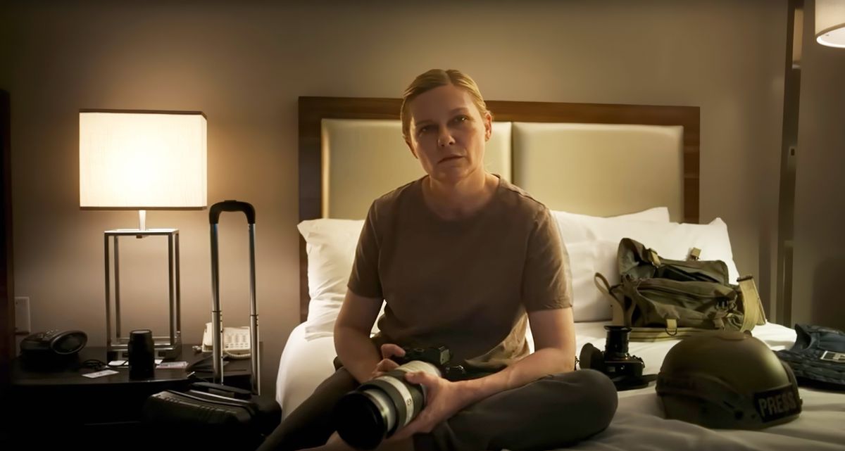 Fotojournalisten Lee (Kirsten Dunst) sitter på en hotellrumssäng och stirrar direkt in i kameran i Alex Garlands inbördeskrig