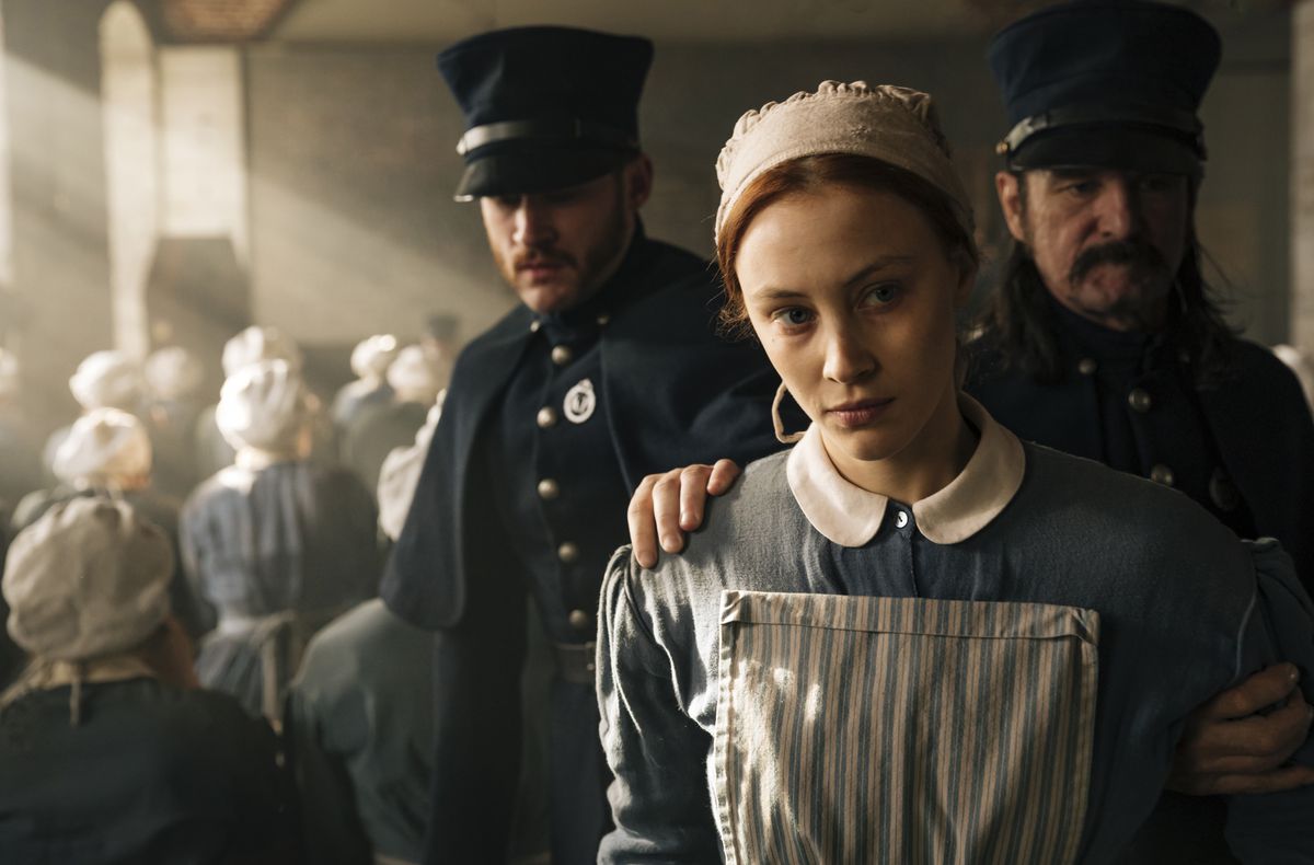 Sarah Gadon, klädd i kolonialklädsel från mitten av 1800-talet, leds bort av poliser i Alias ​​Grace.