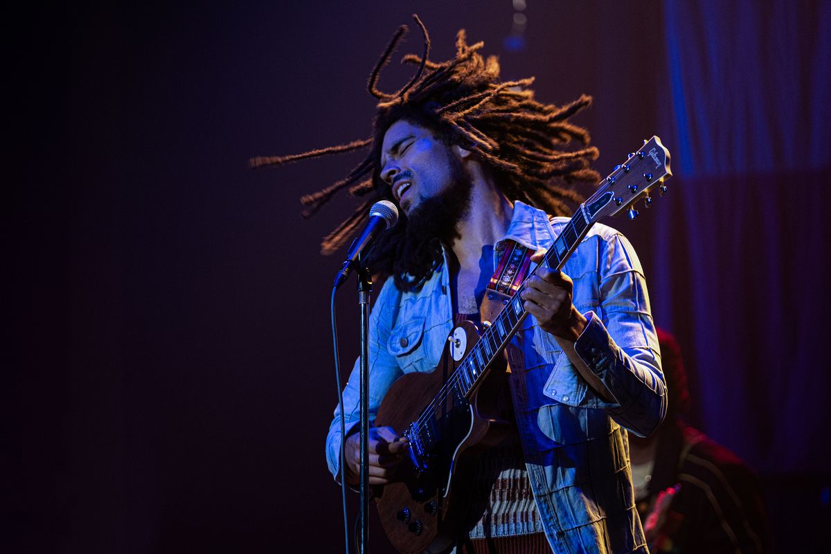 Kingsley Ben-Adir som Bob Marley som rockar och svänger med sina dreadlocks på scenen medan han spelar gitarr i filmen One Love