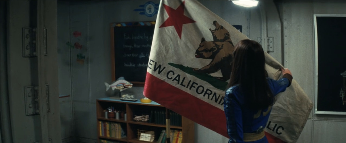 Lucy (Ella Purnell) håller upp flaggan i New California Republic i Vault 4
