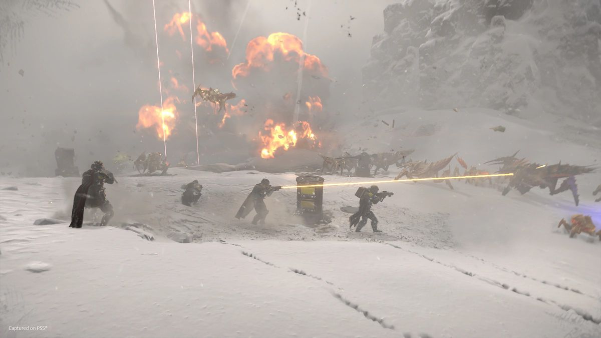 Helldivers som bär vapen slåss mot främmande insekter i ett snöigt landskap, med explosioner i bakgrunden