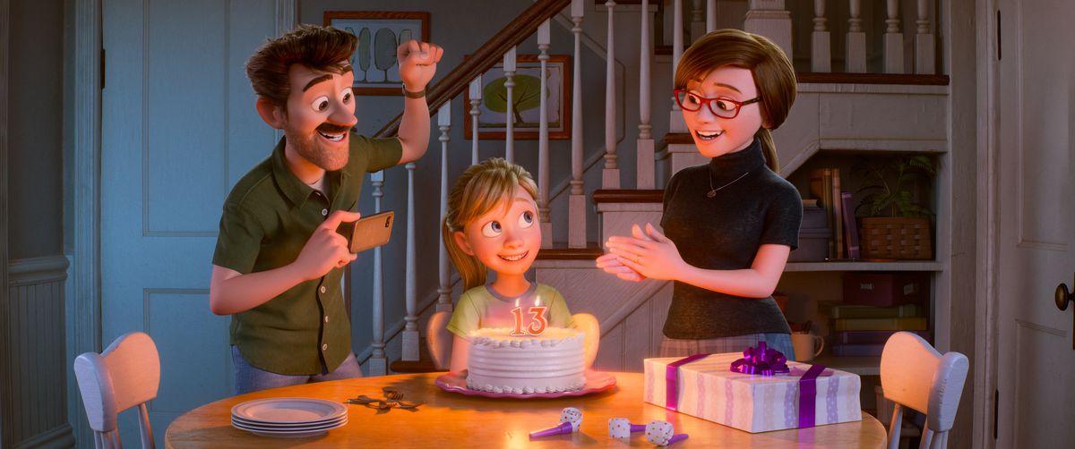 Riley firar sin födelsedag när hon sitter vid matbordet med en tårta, medan hennes pappa och mamma hejar på.