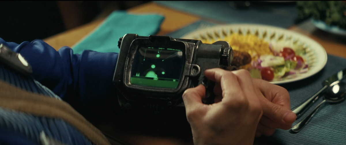 En närbild av någon som spelar Atomic Command på hans Pip-Boy från Fallout avsnitt 1