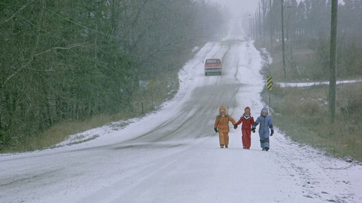 Ungen från The Brood går nerför en snöig gata i snödräkter och håller varandra i hand.