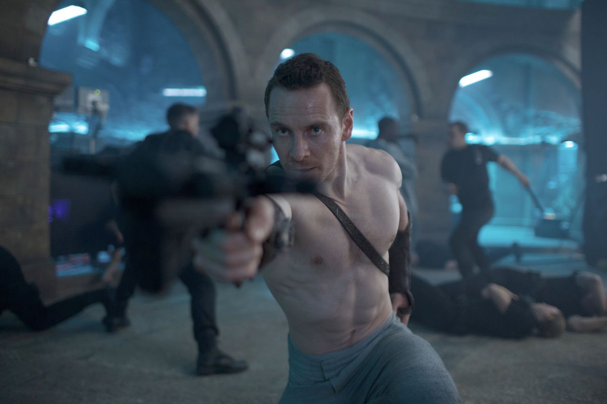 Cal Lynch (Michael Fassbender, bar överkropp och korthårig) står i ett rum fullt av stenvalv, där svartklädda män slåss eller har blivit nedskjutna i bakgrunden, och riktar en enorm, suddig pistol mot kameran i Assassin's Creed, filmen från 2016