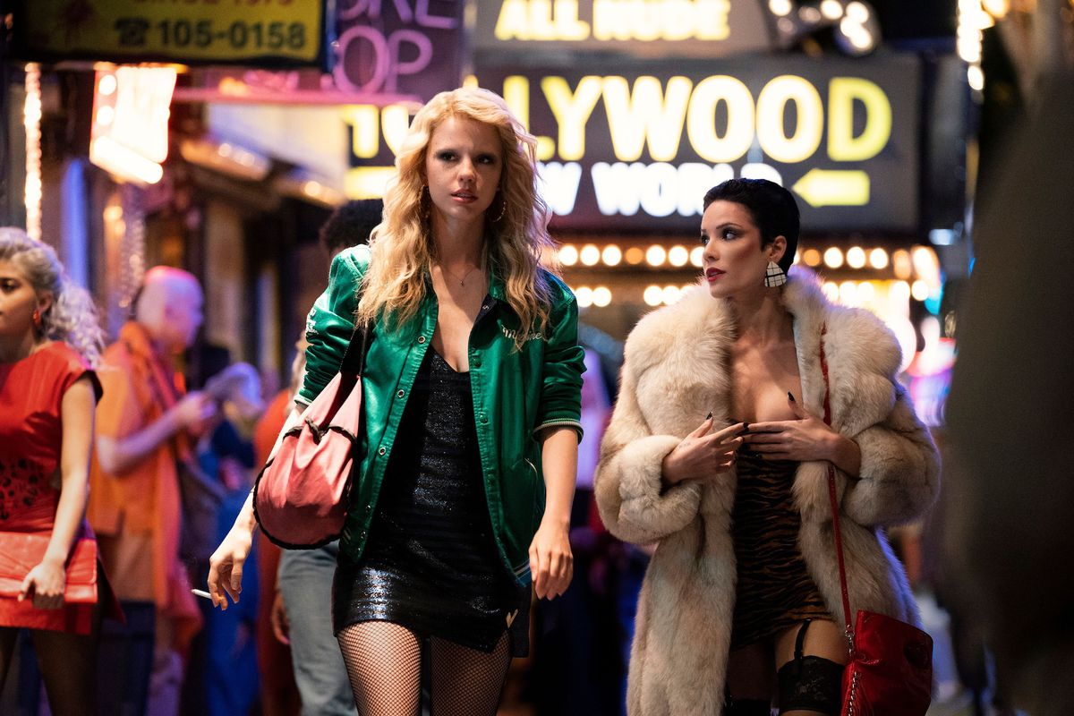 Two women in short dresses, walk down a Hollywood street together in MaXXine.