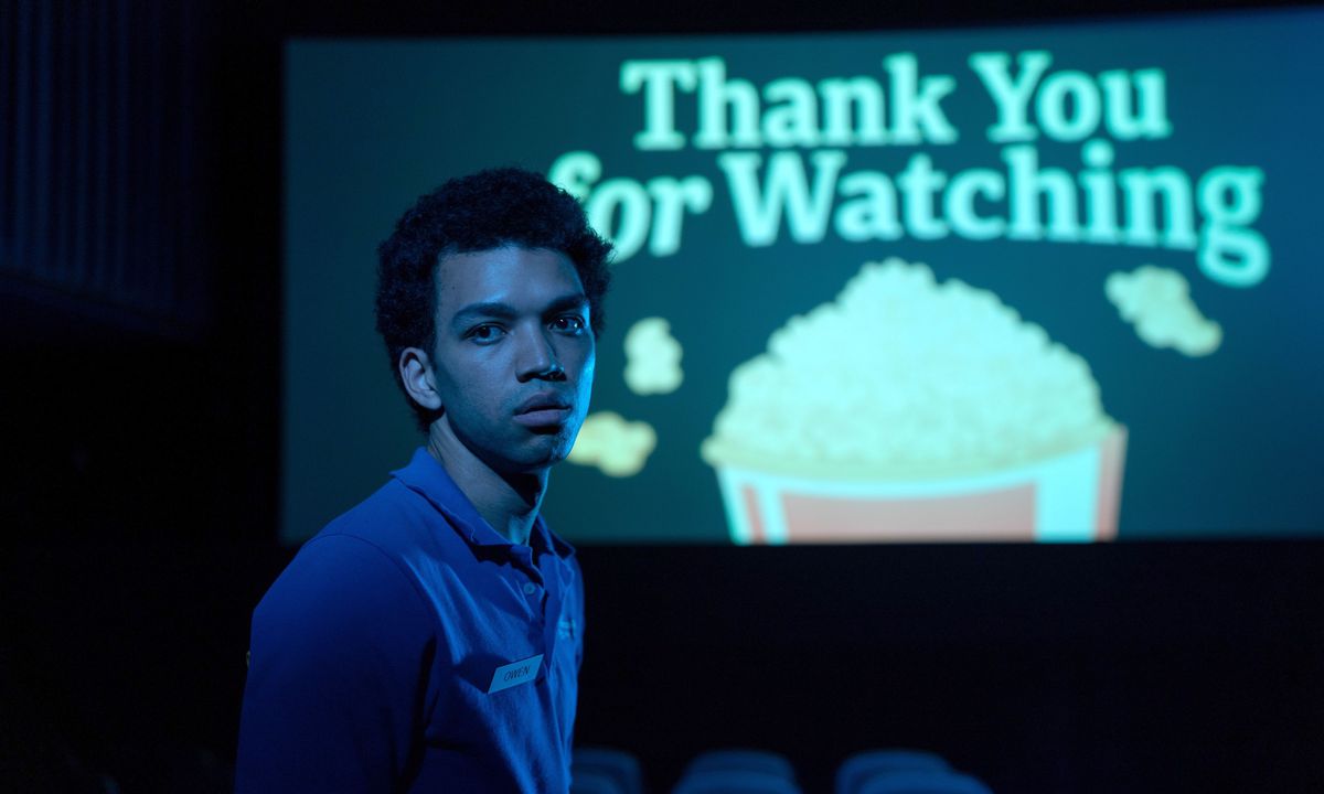 Twentysomething-biografanställde Owen (Justice Smith) står på en mörk teater och tittar på kameran, med en bild på skärmen bakom sig som säger 