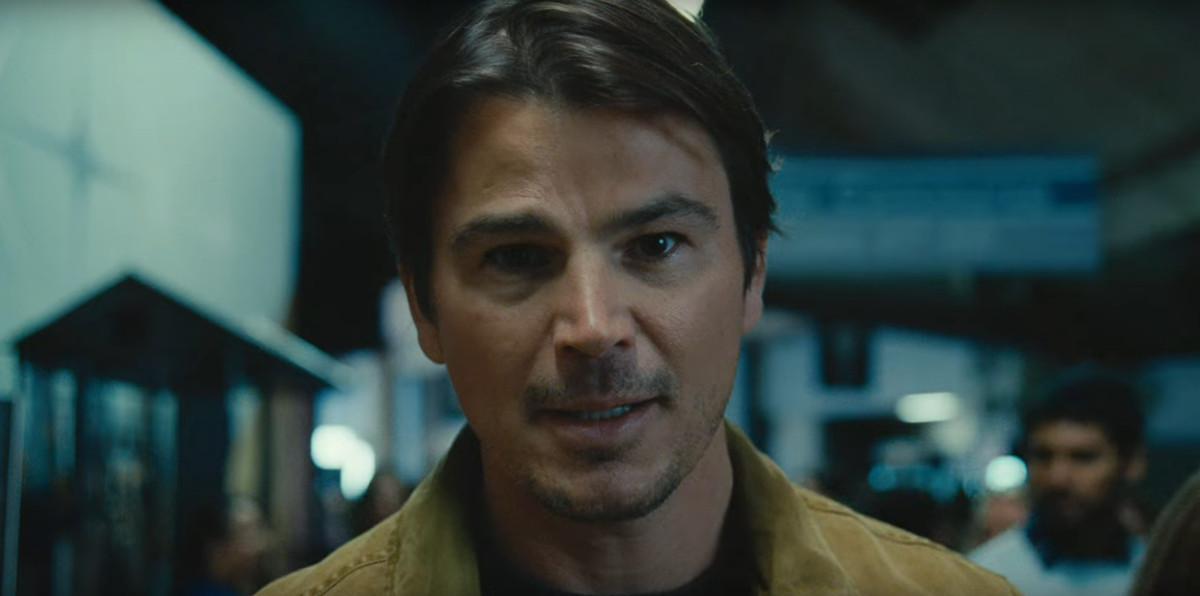 Josh Hartnett wearing a brown jacket and unassuming smile in a closeup from the movie Trap