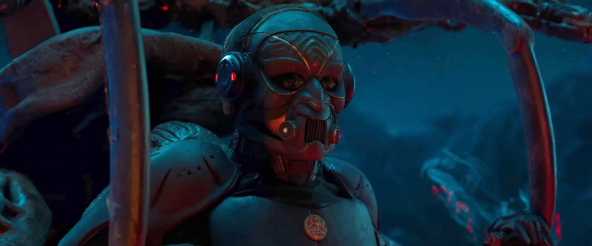 i en reklamfilm för den indiska sci-fi storfilmen Kalki 2898 AD, en humanoid figur i metallrustning och mask sitter i ett mörkt utrymme, omgiven av metallbalkar