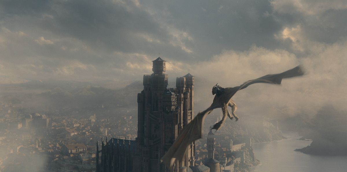 Syrax, en gigantisk gul drake, flyger genom himlen på King's Landing mot Red Keep in House of the Dragon