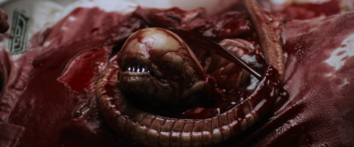 A xenomorph uncoiling from Kane’s chest in Alien (1979).
