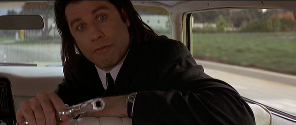 John Travolta, turned around in a car with a gun pointing towards the back seat, about to blow poor Phil LaMarr’s head off in Pulp Fiction