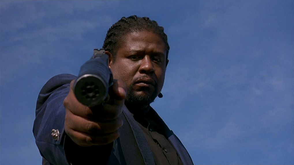 Forest Whitaker as Ghost Dog aiming a silenced pistol in Ghost Dog: Way of the Samurai.