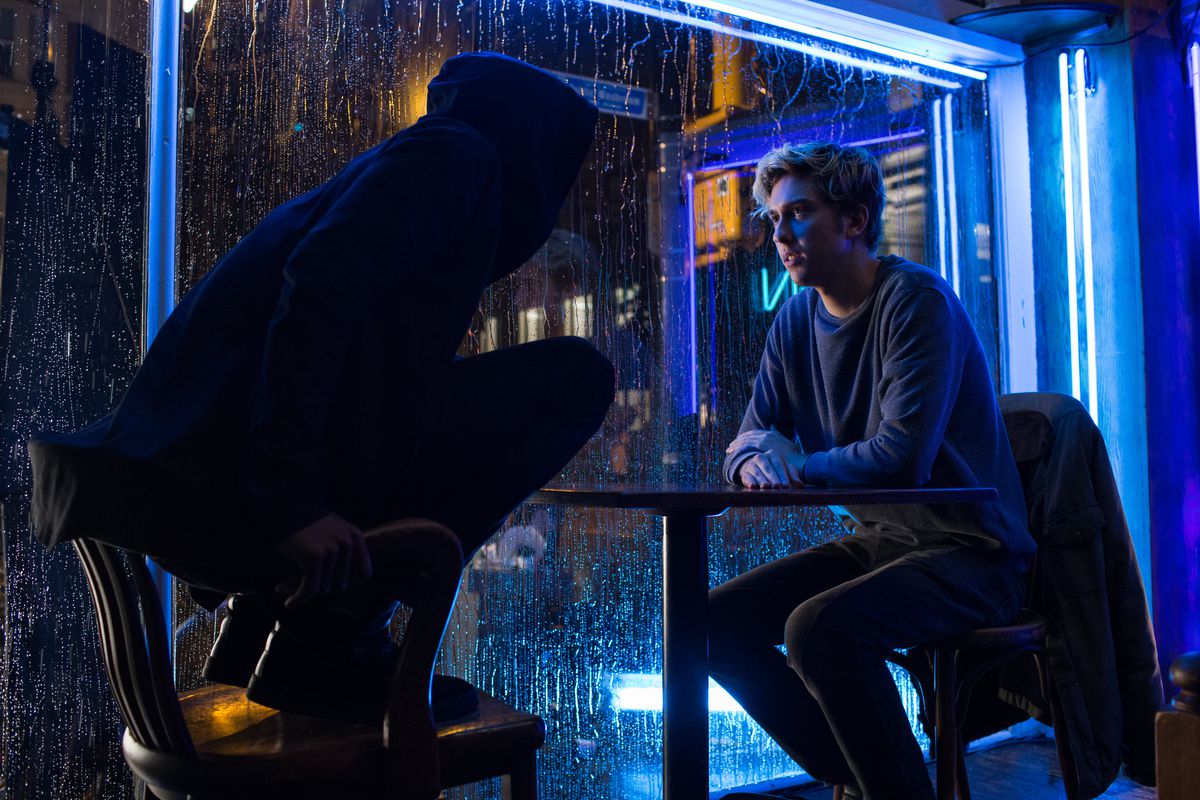 I en stillbild från Netflix live-action Death Note-film står Lakeith Stanfield på en stol som L medan han sitter mittemot Nat Wolff som Light