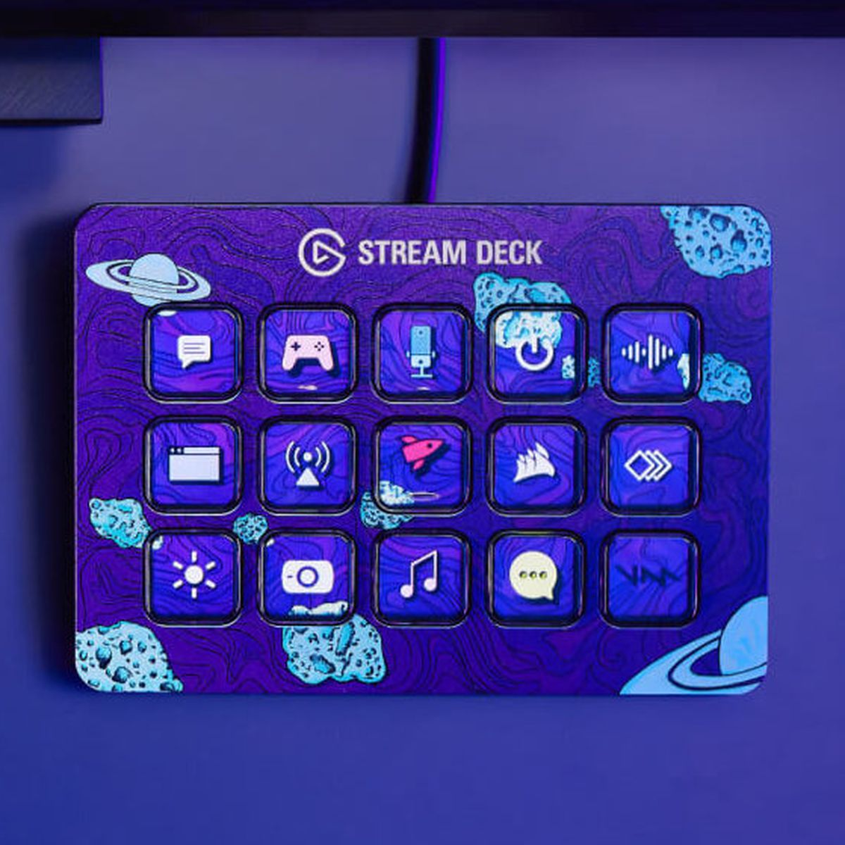 Elgato Stream Deck Mk.2-enheten sitter på ett lila skrivbord med en interstellär frontplatta.